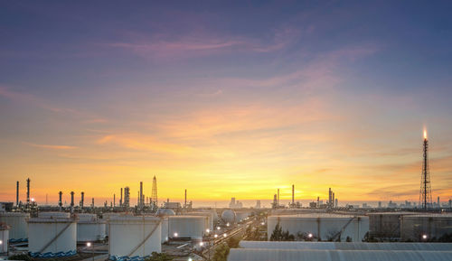 Illuminated city against sky during sunset