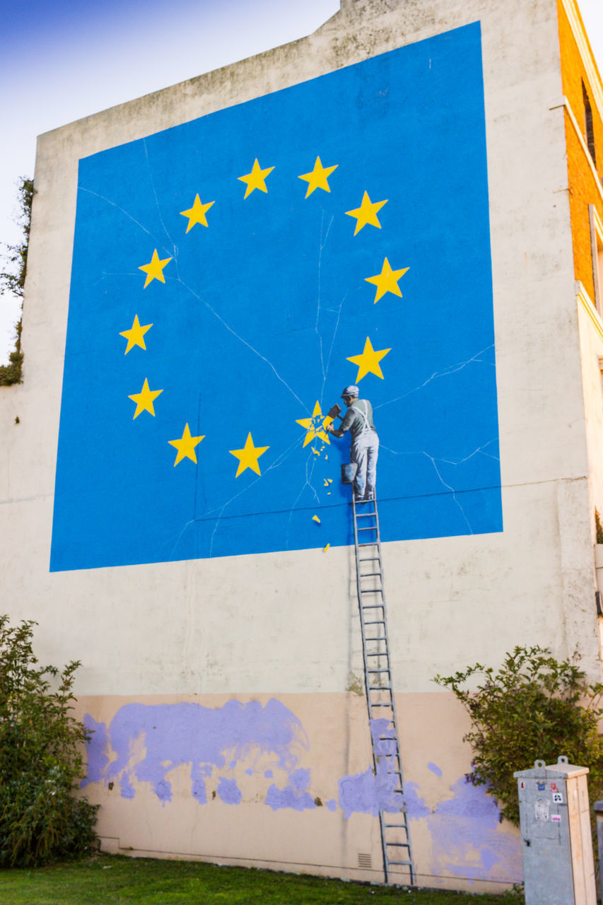 LOW ANGLE VIEW OF FLAGS ON WALL AGAINST BUILDING