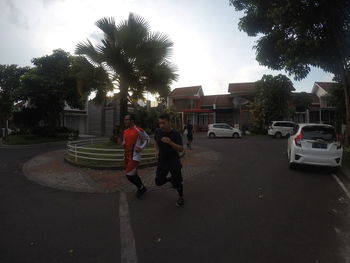 People on street in city against sky