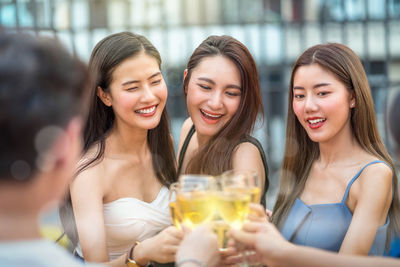 Portrait of a smiling young woman drinking glass