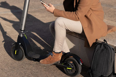 Unrecognizable crop man activating the electric scooter app on the phone before going to work 