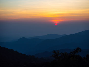 Scenic view of silhouette mountains against sky at sunset