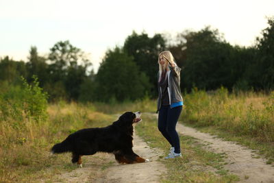 Full length of woman with dog against plants