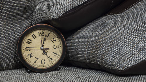 Close-up of clock on bed