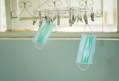 Close-up of clothes hanging on clothesline against wall