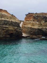 Rock formations by sea against sky