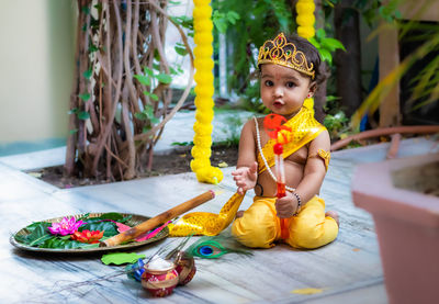 Adorable infant dressed as hindu god krishna cute facial expression with flute at janmashtami