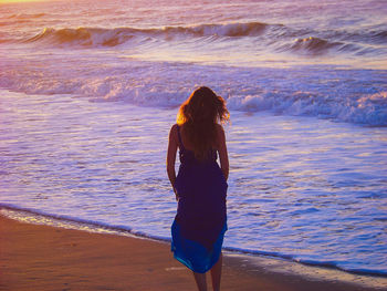 Rear view of woman standing on beach