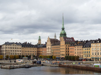 Buildings in city against cloudy sky