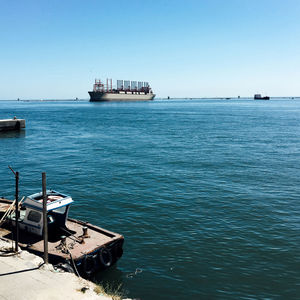 Ship moored on sea against clear blue sky