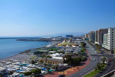 High angle view of city by sea against clear sky