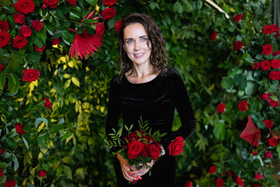Portrait of smiling woman against flowering plants
