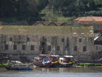 Boats moored on river against buildings
