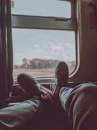 Low section of man sitting in train
