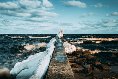 Pier at sea against sky