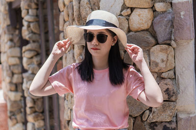 Portrait of young woman wearing sunglasses standing outdoors