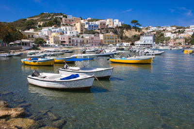 Boats moored in harbor against buildings in city