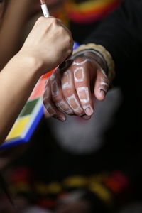 Midsection of person holding multi colored hand