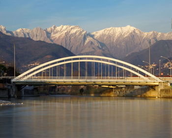 Bridge over river by mountain against sky