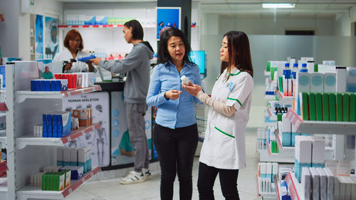 Portrait of female friends standing in laboratory