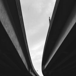 Low angle view of bridge over buildings against sky