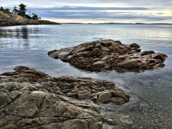 Scenic view of rocks on beach against sky