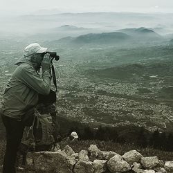 Man photographing on landscape against sky