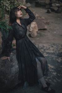 Low angle view of woman standing on rock