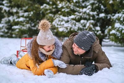 Side view of mother and daughter on snow