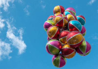 Low angle view of multi colored candies against blue sky