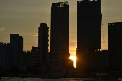 Modern buildings against sky during sunset