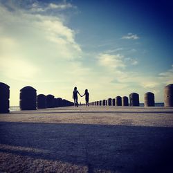 Man at cemetery against sky