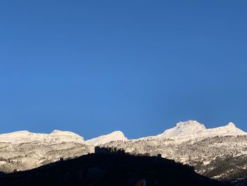 Scenic view of snowcapped mountains against clear blue sky