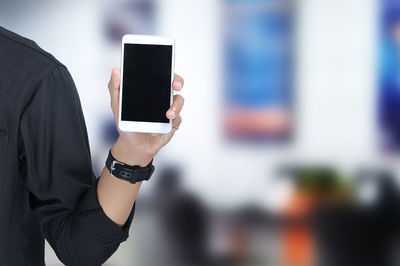 Young asian man showing blank smartphone screen