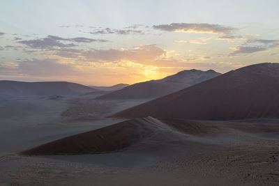 Scenic view of desert against sky during sunset