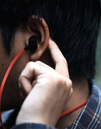 Close-up of man listening music through headphones