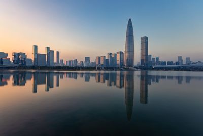 Reflection of buildings in city at sunset