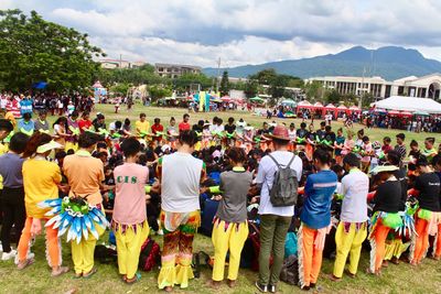 Rear view of people walking in city against sky