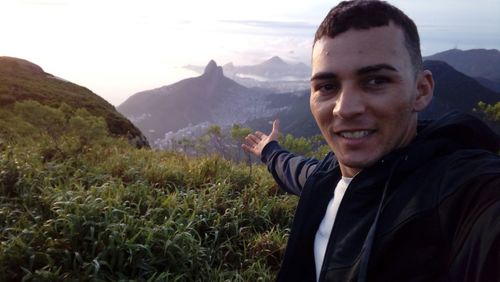 Portrait of smiling man standing on mountain