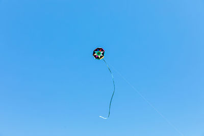 Low angle view of kite flying against blue sky