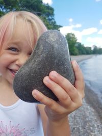 Close-up portrait of cute girl holding stone