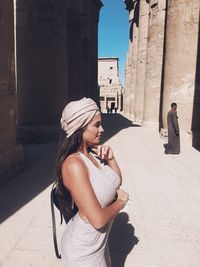 Young woman standing against built structure