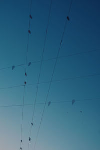 Low angle view of cables against clear blue sky