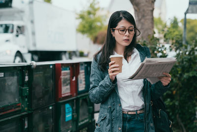 Young woman standing with coffee