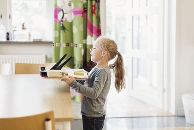 Girl carrying food tray in preschool