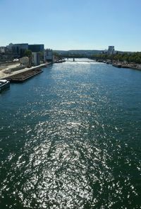 Scenic view of river by buildings against clear sky
