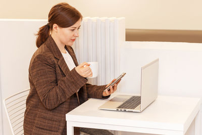 Young businesswoman using laptop at office