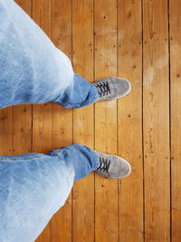 Low section of man standing on hardwood floor