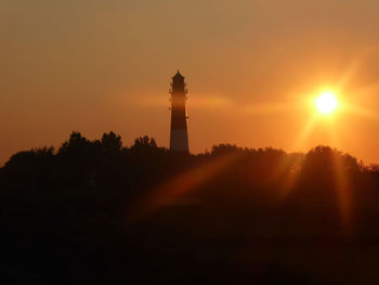 Silhouette lighthouse against sky during sunset