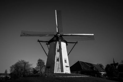 Low angle view of traditional windmill against clear sky